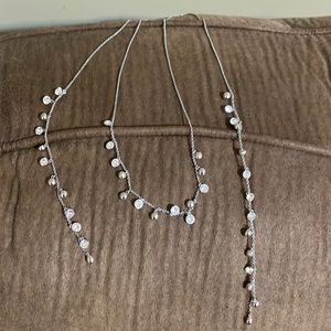 This is a silver necklace with white Swarovski crystals. It is a wrap necklace.
